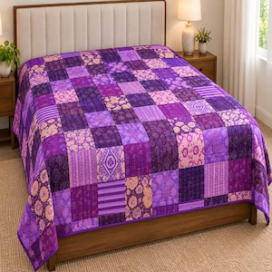 Könnte beinhalten: Eine Patchwork-Tagesdecke mit verschiedenen violetten und lila Stoffquadraten in unterschiedlichen Mustern, darunter florale, geometrische und gestreifte Designs. Die Decke liegt auf einem Bett mit hellem Kopfteil und Holzrahmen.