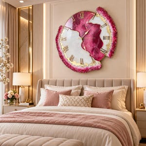 May include: A large, circular wall clock featuring a swirling magenta and white resin design with gold-toned Roman numerals. The clock has a textured, crystalline border in shades of deep pink and magenta, with thin gold hands at the center.