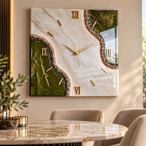 May include: A square wall clock featuring a white marble-effect center with gold veins, flanked by deep olive green sections. The clock face includes gold Roman numerals at the twelve, three, six, and nine positions, gold hands, and textured gold glitter accents.