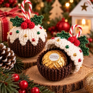 Peut inclure: Deux décorations de Noël en crochet en forme de pudding, l'une fermée et l'autre ouverte, révélant un chocolat Ferrero Rocher emballé dans du papier doré. Chaque pièce présente une base marron, un glaçage blanc, du houx vert et des baies rouges.