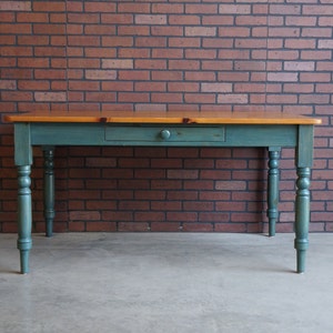 May include: A teal blue farmhouse table with a single drawer and turned legs. The table top is made of natural wood.