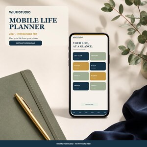 May include: A smartphone displaying a digital planner interface titled Your Life, At A Glance with navigation buttons for 2027 Year, Months, Weeks, Daily, Goals, Habits, Money, and Notes. The screen features a clean layout with dark blue, gold, and sage green accents.