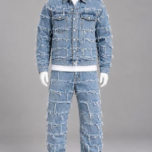 Peut inclure: Un ensemble veste et pantalon en jean bleu clair composé de panneaux horizontaux avec des bords effilochés sur toute la surface. La veste présente un col, une fermeture boutonnée et deux poches poitrine. Un t-shirt blanc uni et des baskets blanches.