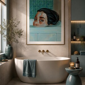 Könnte beinhalten: Ein gerahmter Kunstdruck, der eine Person mit dunklem Haar in einer hellblauen Badewanne vor einem grün gefliesten Hintergrund zeigt. Das Kunstwerk hängt über einer weißen freistehenden Badewanne mit einem blaugrünen Handtuch und Beistelltisch.