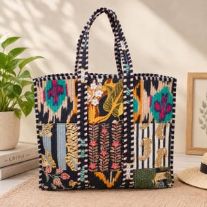 Op de afbeelding: Een gewatteerde tote bag met een patchworkontwerp met diverse patronen, waaronder tijgerstrepen, luipaardvlekken, bloemmotieven en abstracte vormen in zwart, wit, geel, roze en blauwgroen. De tas heeft twee zwart-wit gestreepte handvatten.