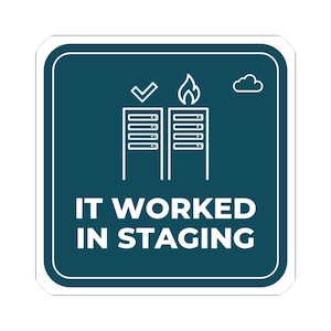 May include: A square dark teal sticker with white text that reads IT WORKED IN STAGING. Above the text are two white server rack icons, one with a checkmark and one with a flame, plus a small cloud outline in the top right corner.