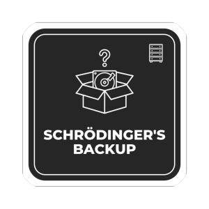 May include: A square black sticker with white rounded corners featuring a white line art graphic of an open box containing a hard drive, a question mark above it, a small chest of drawers icon, and the text SCHRÖDINGER'S BACKUP in white.