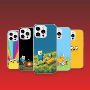 May include: Five smartphone cases featuring Adventure Time characters. Designs include a rainbow background with Jake, Finn roasting marshmallows by a fire, Finn and Jake walking in a field with BMO, a group scene, and a yellow case with Jake's face.