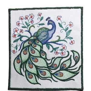 May include: Embroidered patch featuring a peacock with a green and blue body and a large, detailed green and blue tail. The peacock is surrounded by small white flowers with orange centers.