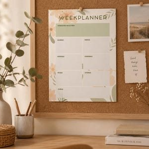 Op de afbeelding: Een weekplanner met de tekst WEEKPLANNER en Nederlandse dagbenamingen, voorzien van een lichtgroene koptekst en zachte bloemenillustraties in perzik- en groentinten, bevestigd op een prikbord naast een notitie met de tekst Good things take time.