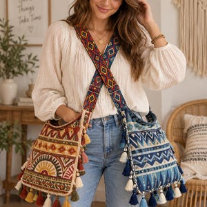 Puede incluir: Dos bolsos cruzados con un patrón geométrico tejido y borlas decorativas. Un bolso presenta tonos cálidos de rojo, naranja y amarillo, mientras que el otro muestra tonos de azul y blanco. Ambos bolsos comparten una correa ancha y colorida.