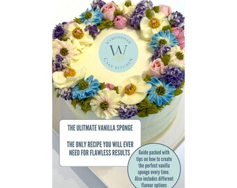 Könnte beinhalten: Ein runder Kuchen, verziert mit aufgespritzten Buttercremeblumen in Blau, Lila, Rosa und Weiß. In der Mitte befindet sich das Logo von Wymondham Cake Kitchen. Der Text lautet: THE ULTIMATE VANILLA SPONGE. THE ONLY RECIPE YOU WILL EVER NEED FOR FLAWLESS RESULTS.
