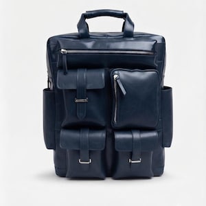 May include: A dark navy blue backpack featuring a top handle, a horizontal zippered pocket, and four front pockets with flap closures and silver-toned metal buckles. The bag includes two side slip pockets and a smooth, structured exterior finish.