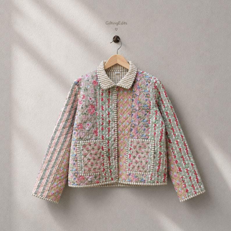 May include: A quilted jacket featuring a patchwork design of floral patterns in shades of pink, green, and blue. The jacket has a collared neckline, long sleeves, two front patch pockets, and a button-down front closure. The text GiftingEdits is visible.