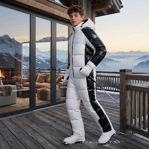 May include: A white and black hooded ski suit featuring a quilted puffer design, a full-length front zipper, and long sleeves with matching white gloves. The garment has a color-blocked aesthetic with black side panels and a logo patch on the arm.