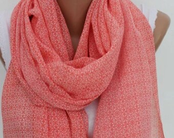 Peut inclure: Une écharpe rose corail avec un motif floral blanc. L'écharpe est faite d'un tissu léger et est parfaite pour le printemps et l'été.