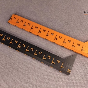 Op de afbeelding: Twee L-vormige meetinstrumenten, een oranje en een zwarte, voorzien van gedrukte numerieke schalen van 10 tot 19 en 1 tot 2. De instrumenten hebben een driehoekig uiteinde en bevatten de tekst HARTH in de rechterbovenhoek.