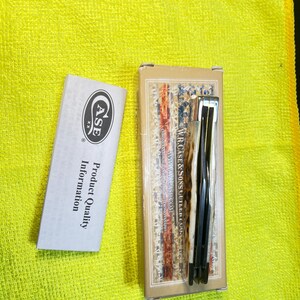 May include: A folding pocket knife with a textured cream and brown handle, resting on its rectangular cardboard box labeled W.R. Case & Sons Cutlery Co. Next to it is a white paper insert with the Case XX logo and Product Quality Information text.