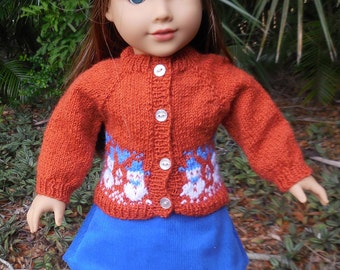Hand knitted orange-red sweater with a border of snowmen, a matching hat, and a blue skirt made for American Girl and similar 18 inch dolls