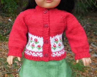 Hand knitted red sweater with a flower design, red beret, and a green skirt made to fit American Girl and similar 18 inch dolls.