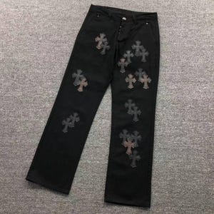 Könnte beinhalten: Schwarze Jeanshose mit geradem Bein, Knopfleiste und mehreren dunkelgrauen, kreuzförmigen Aufnähern, die auf der Vorderseite beider Beine angebracht sind. Der Stoff ist einfarbig schwarz und weist sichtbare Nähte auf.