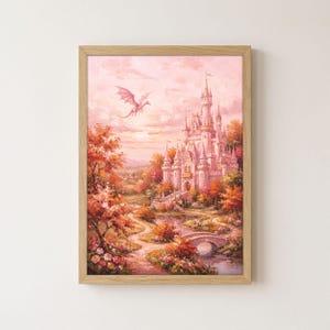 May include: A framed wall art print featuring a fantasy landscape with a large castle in soft pink and orange hues. A dragon flies in the sky above the castle, which is surrounded by autumn-coloured trees, a winding path, and a stone bridge.