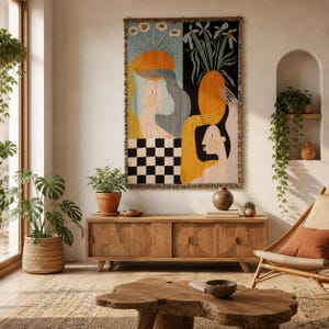 Pode incluir: Uma tapeçaria de parede retangular tecida com um design de painel dividido. O lado esquerdo mostra uma figura estilizada com um fundo azul e uma base xadrez preta e branca. O lado direito exibe um vaso com flores sobre um fundo preto.