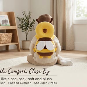 May include: A yellow and brown bee-shaped head protection cushion worn like a backpack. The plush accessory features a circular head pad, two white wings, and adjustable shoulder straps. The text Gentle Comfort, Close By is visible below.