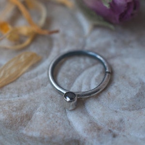 Sterling silver minimalist septum ring in 16 gauge oxidised 925 silver with black diamond. The ring twists to open/close.