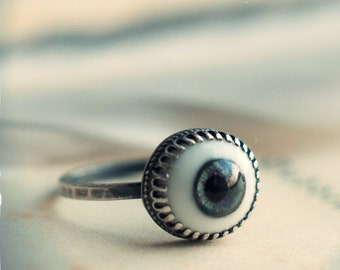 Sterling silver evil eye ring with a realistic human glass dolls eye. A protection amulet for witchy folk in blue, green, grey, and brown.