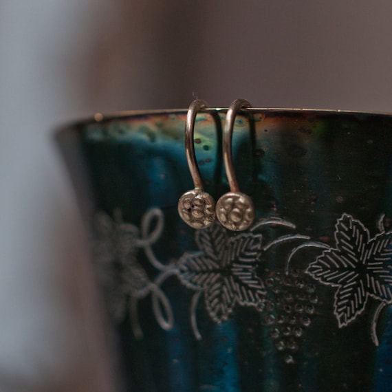 Gold flower earrings inspired by apotropaic protection magic hex signs.