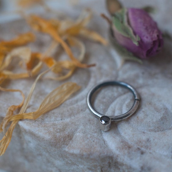 Sterling silver minimalist septum ring in 16 gauge oxidised 925 silver with black diamond. The ring twists to open/close.