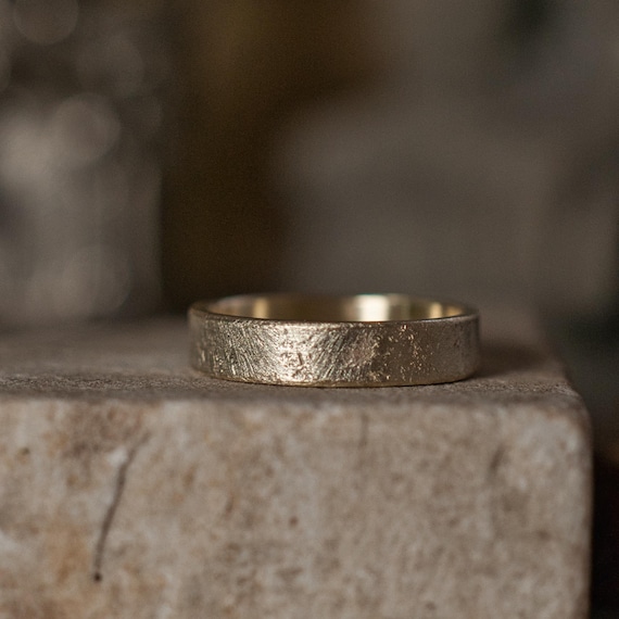 Rustic gold wedding ring, 5mm wide band textured against stone and gender neutral for him, her or they.
