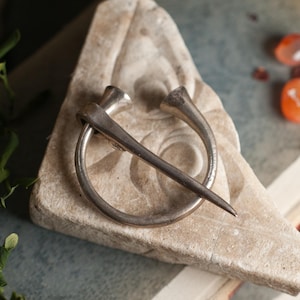 Antique silver penannular brooch or shawl pin, in a timeless minimalist design for fastening fabric. Witchy elegance perfect for gift giving