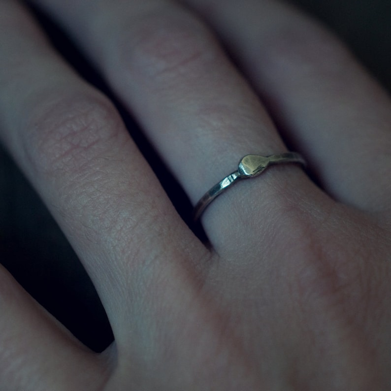 Op de afbeelding: Een eenvoudige zilveren ring met een klein, rond, gehamerd detail.