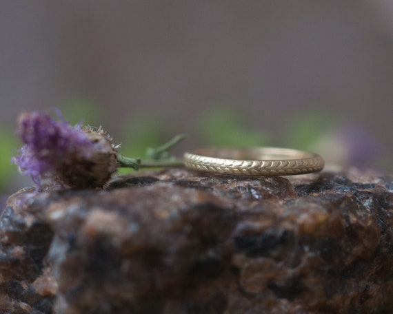 Gold wedding ring with a wheat pattern symbolising fertility growth prosperity and rebirth, a simple stacker or alternative mourning ring.