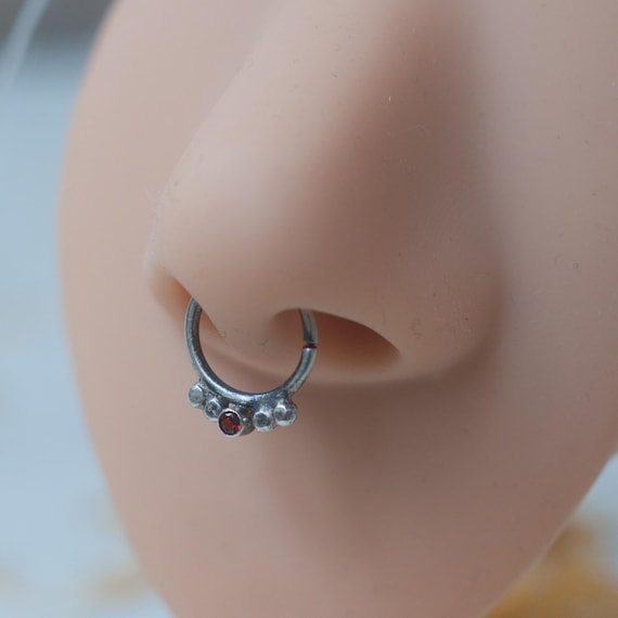 Sterling silver septum ring in 16 gauge oxidised 925 silver with garnet and bead decoration. The ring twists to open/close.