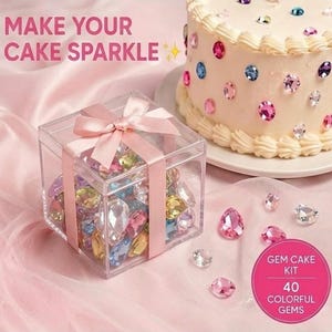 May include: A clear square box with a pink ribbon containing assorted colorful teardrop-shaped gems, next to a frosted cake decorated with similar gems. Text reads: MAKE YOUR CAKE SPARKLE and GEM CAKE KIT 40 COLORFUL GEMS.