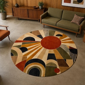 May include: A large circular area rug featuring a geometric pattern with a central rust-colored sunburst design. The rug incorporates various shapes including semicircles, triangles, and stripes in a palette of rust, olive green, navy, and cream.