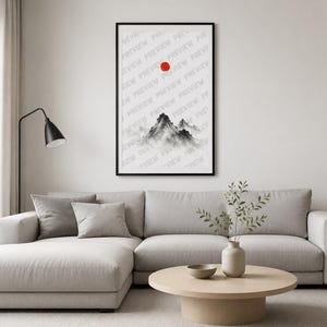 Puede incluir: Una lámina de arte enmarcada que muestra un paisaje montañoso en estilo de tinta china en blanco y negro con un círculo rojo sólido sobre los picos. La obra está en un marco negro fino y contiene un texto de marca de agua repetido.