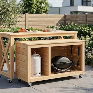 Peut inclure: Un îlot de cuisine d'extérieur en bois clair sur roulettes, composé d'une table de préparation haute et d'un meuble de rangement bas. Le meuble bas contient une bouteille de gaz blanche et un barbecue portable noir.