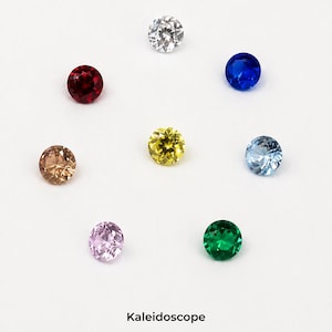 Eight faceted 3 mm round stones in mixed colours on a pale grey background, all the same size, arranged so the full colour range is visible side by side. Labelled Kaleidoscope.
