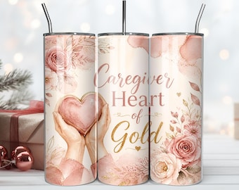 Puede incluir: Un vaso cilíndrico de acero inoxidable con pajita, con un diseño floral de acuarela en rosa suave y dorado. El gráfico incluye dos manos sosteniendo un corazón y el texto Caregiver Heart of Gold en letra elegante y purpurina dorada.