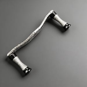 May include: A cabinet handle featuring a wavy, silver-toned metal bar with a hammered texture. The handle includes two cylindrical supports with a hammered silver finish, accented by smooth, solid black rings at the top and bottom ends.