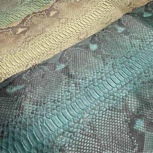 May include: Three pieces of textured snakeskin leather displayed in a row. The top piece is a light olive green, the middle piece is a tan and brown shade, and the bottom piece is a vibrant teal and black with a distinct reptilian scale pattern.