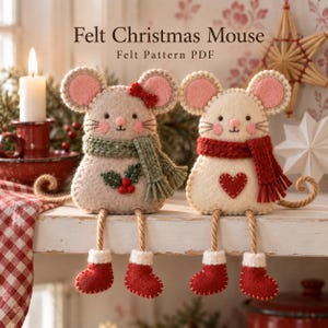 Op de afbeelding: Twee vilten muisornamenten met de tekst Felt Christmas Mouse Felt Pattern PDF. De ene muis is lichtgrijs met een groene sjaal en hulst, de andere is crème met een rode sjaal en hartje. Beide hebben roze oren, rode laarsjes en bungelende poten.