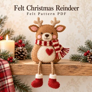 May include: A brown felt reindeer ornament with a red and white striped scarf, a white belly patch with a red heart, and dangling legs wearing red boots. The text reads Felt Christmas Reindeer Felt Pattern PDF at the top of the image.