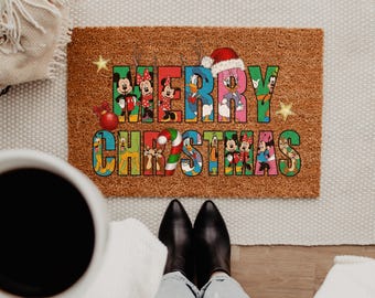 May include: A rectangular brown coir doormat featuring the text MERRY CHRISTMAS in large, colorful block letters. The letters are filled with various Disney characters, including Mickey Mouse, Minnie Mouse, Donald Duck, and Pluto, with a candy cane.