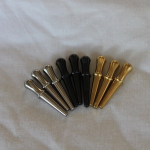 9 High Quality Metal Pegs. ( 3 Silver/Stainless, 3 Black, 3 Brass/Gold colored )