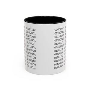 May include: A white ceramic mug with a black interior and rim, featuring a repeating pattern of black binary code sequences printed vertically around the exterior surface. The design consists of multiple rows of zeros and ones in a standard font.